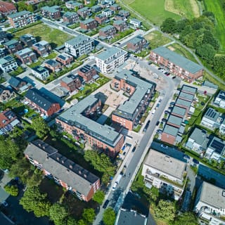 Neubau von zwei MFH mit 83 geförderten Wohneinheiten, Einrichtung für Geflüchtete, Quartiersplatz und Tiefgarage