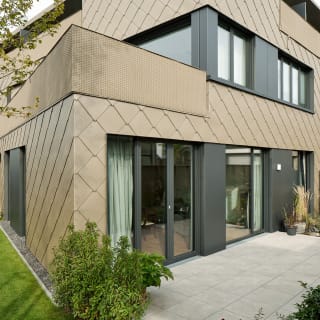 Mehrfamilienhaus mit bronzefarbener Alu-Fassade