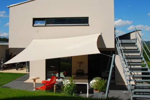 Fest verspanntes Sonnensegel farblich auf die Fassade abgestimmt