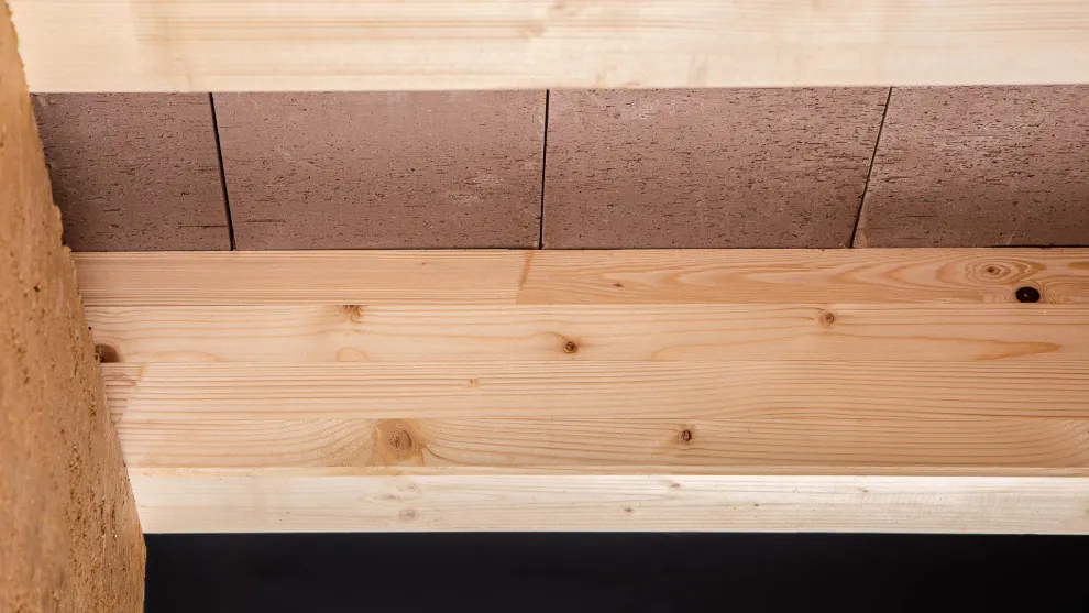 Holz-Lehm-Einhängedecke als Geschossdecke auf Stampflehm-Fertigwand (Foto: Björn Klug)