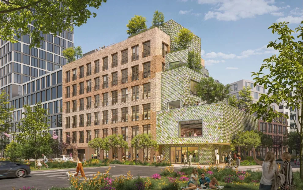 Die zweigeteilte Fassade des Bürokomplexes setzt auf Recyclingbaustoffe. Links: recycelte rotbraune Klinkersteine, rechts: recycelte bunte PVC-Schindeln.