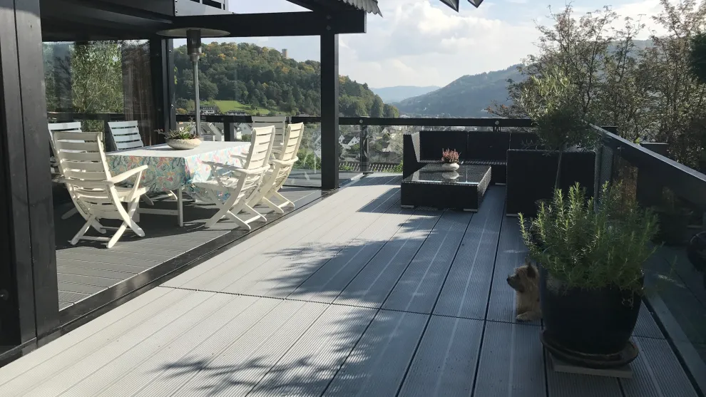 Mit glasfaserverstärkten TRIMAX®-Terrassendielen aus Kunststoff belegte Terrasse mit Ausblick in den Naturpark Lahn-Dill-Bergland