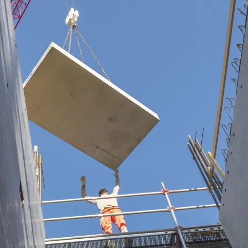 Auch bei Treppen kann der Bauablauf mit effizienten Lösungen und Bauteilen deutlich beschleunigt werden. Im Bild: Ein mit dem Trittschalldämmelement Schöck Tronsole® vorgefertigtes Treppenpodest wird in Rekordzeit in das bestehende Gebäude eingehoben und schallisoliert fixiert.
