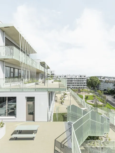 Passend zur Topografie richteten die Architekten das Gebäude terrassenförmig mit Blick ins Grüne nach Süden hin aus – mit Balkonen und Terrassen wie die hängenden Gärten von Semiramis.