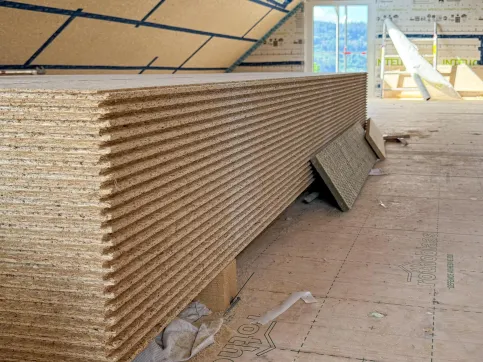 Ein Stapel esb-Plus Platten mit Nut & Feder-Verbindung steht griffbereit auf dem Dachboden.