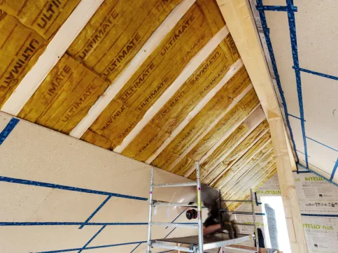 Ein Zimmermann beplankt den Dachstuhl mit esb-Plus Holzbauplatten.