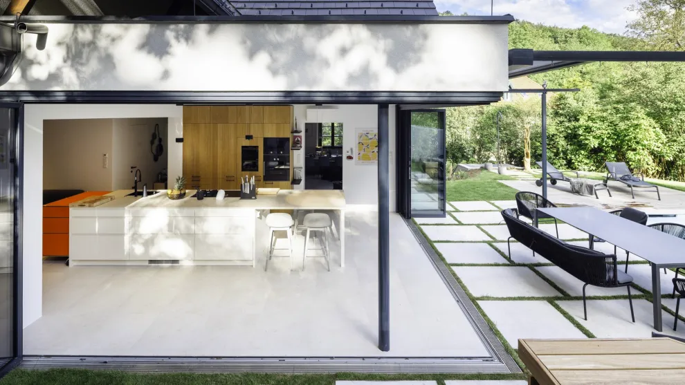 Die raumhohe Aluminium-Glas-Faltwand, die sich vollständig über Eck öffnen lässt, dient als verbindendes Element zur Natur. Projekt: Sanierung und Erweiterung von studio stark.