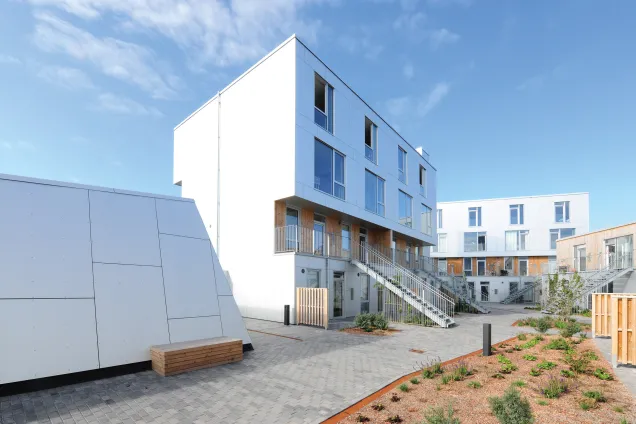 Den nachhaltigen Charakter des Quartiers unterstützt auch die Bauweise der Wohngebäude, die aus vorgefertigten Holzmodulen montiert wurden.