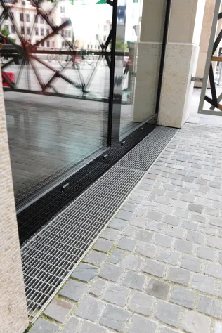 An der Fassade der Gastronomie wurden Drainagerinnen des Typs „Hydra“ mit Maschenrosten aus Edelstahl eingesetzt.