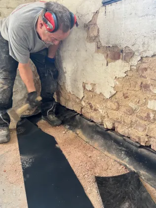 Verkeilen der Schnittfuge mit statisch belastbaren Kunststoffkeilplatten im Abstand von ≤ 25 cm über den gesamten Mauerquerschnitt (Belastbarkeit ≥ 500 kp/cm2).