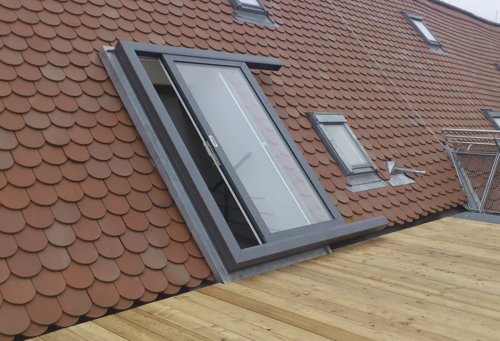 Integriert in das Schrägdach schaffen Balkonausstiegsfenster Zugang zu Balkon oder Terrasse.