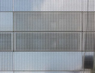 Hebefaltladen verschließen die Fassade und spiegeln eine einheitliche “Gebäudehülle”