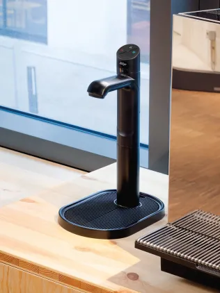 Zip-Armatur mit Tableau neben einem Kaffeeautomaten.