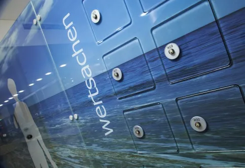 Flächenbündig integrierte Wertfächer in eine Glasumkleideanlage mit kundenindividuellem Motivdruck