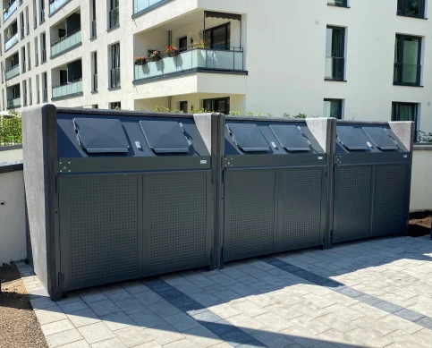 VR-Müllbox für Container / Tonnen bis 1100 Liter. Durchgefärbter anthrazitgrauer Sichtbeton, pulverbeschichtete Stahlteile nach RAL 7016 und Design Typ P Türen. Mit verschließbaren Einwürfen