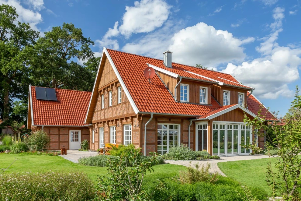 Ist schon die Fassade dieses Landhauses mit Klinkern und Fachwerk ein Hingucker, wird das romantische Gesamtbild erst mit dem Hohlfalzziegel Z5 in der Oberfläche toskanarot matt komplett.