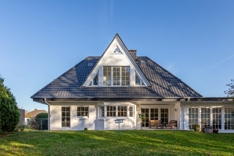 Ein Einfamilienhaus mit einem Walmdach, welches mit dem J11v in lavagrau matt eingedeckt wurde. Außerdem wurde hier das JaWaFlex Universalanschlussband am Kaminanschluss verwendet.