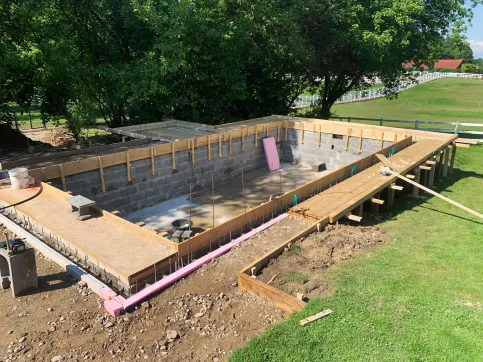 Die Poolwände aus Schalungssteinen werden mit einer Bodenplatte aus Ortbeton kombiniert und mit dieser konstruktiv verbunden.